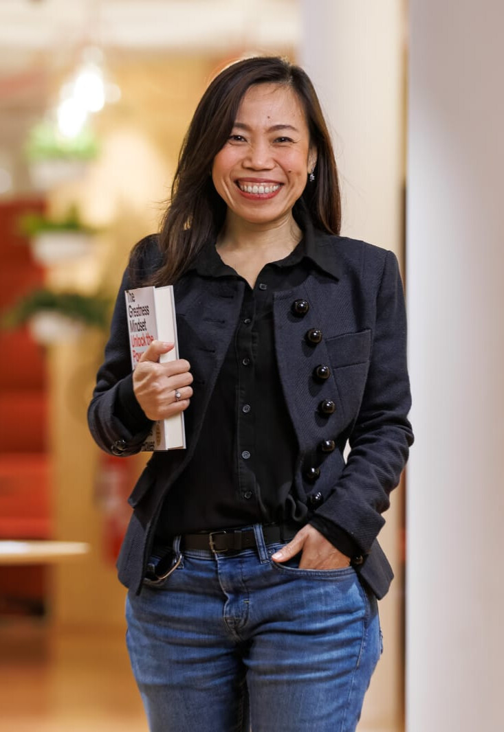 Mayuree holding a book and smiling